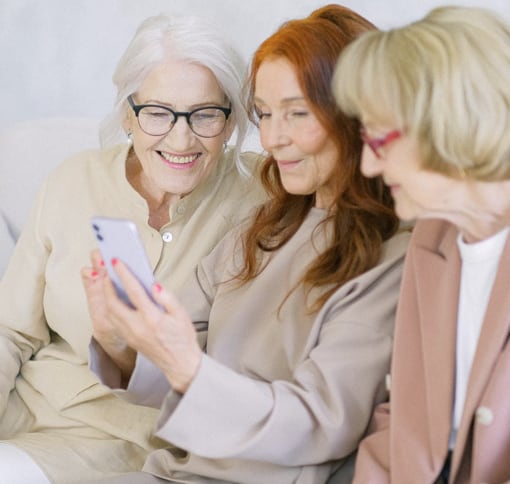 Three women looking at a phone